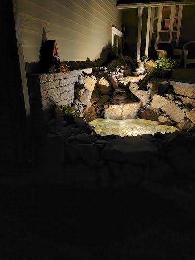 Water feature with uplighting and stone surround at night, Hockinson WA