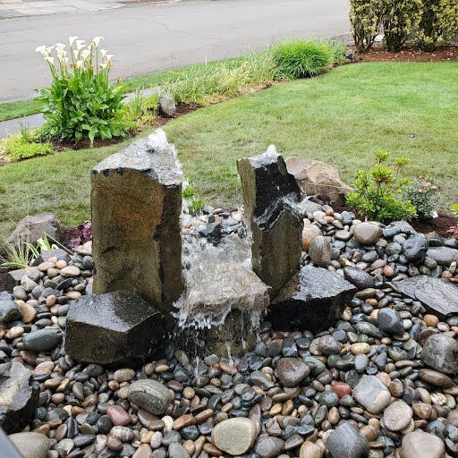 Basalt column water feature with gravel surround, Pacific Northwest landscape